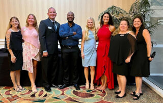 8 people lined up taking a picture at a gala